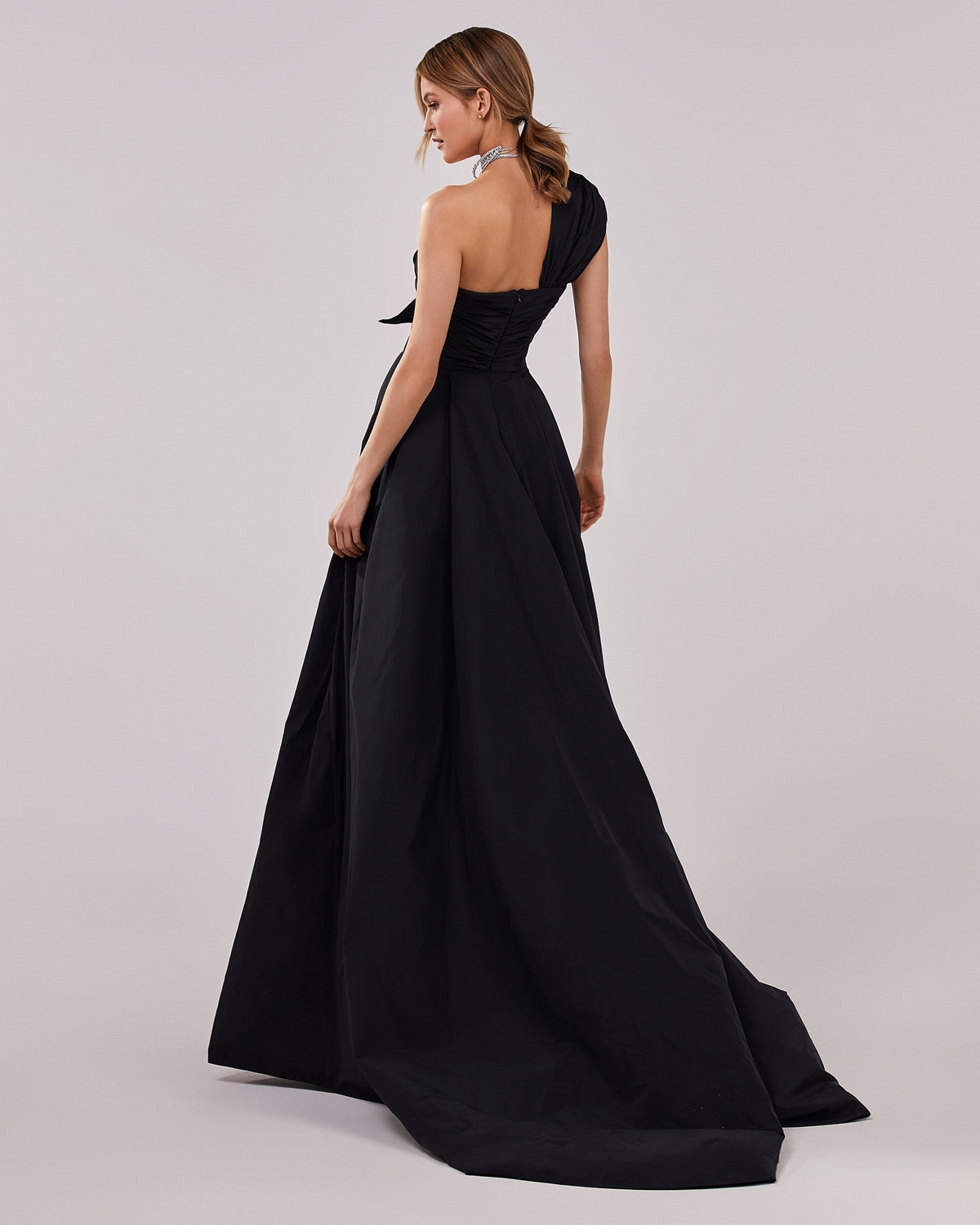 Black taffeta evening gown with a high slit and one shoulder wrap top