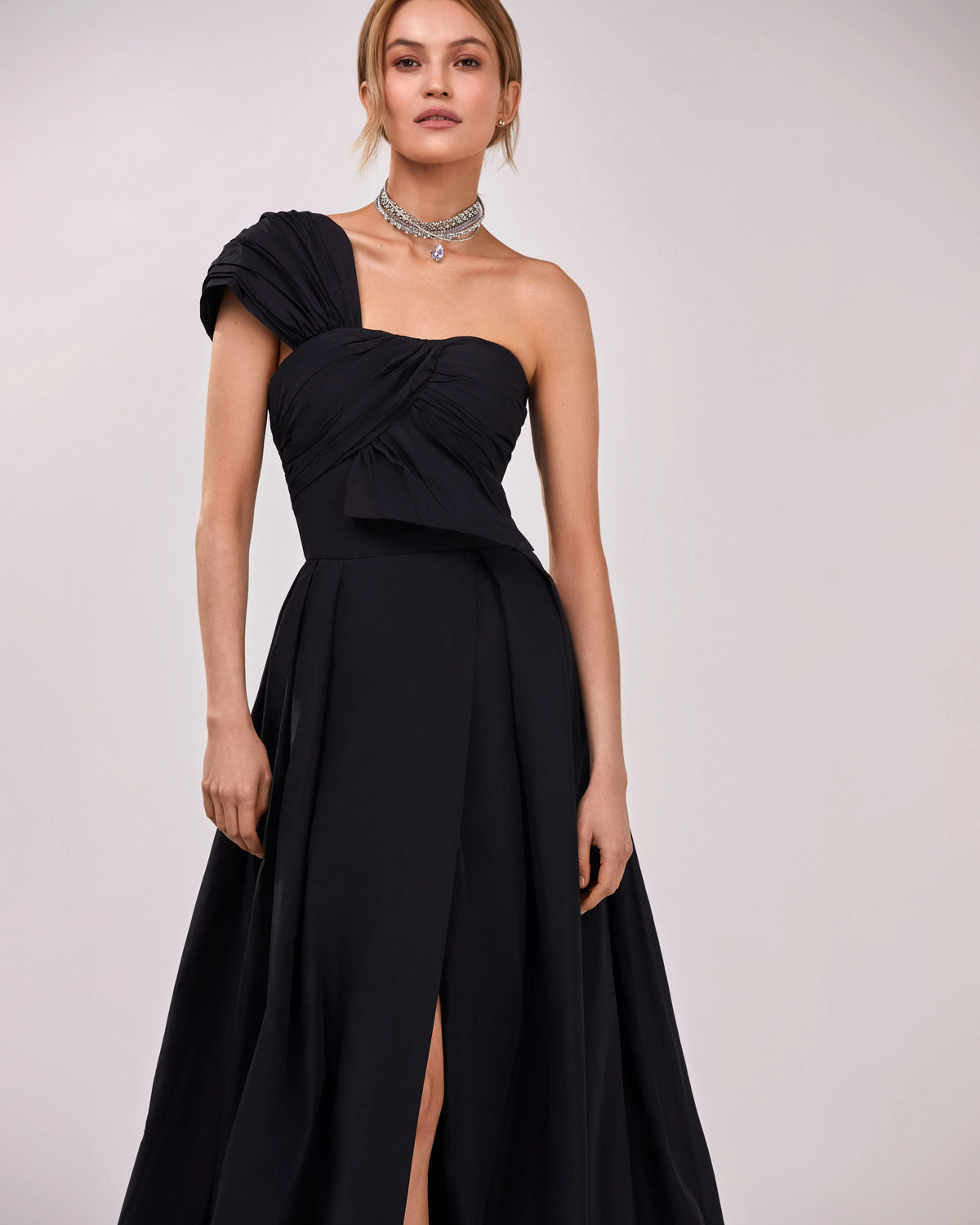 Black taffeta evening gown with a high slit and one shoulder wrap top